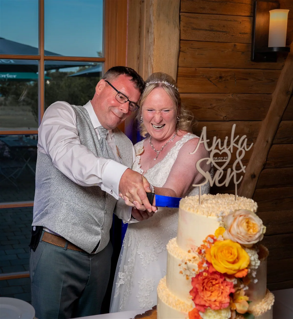 A couple cut their wedding cake together.