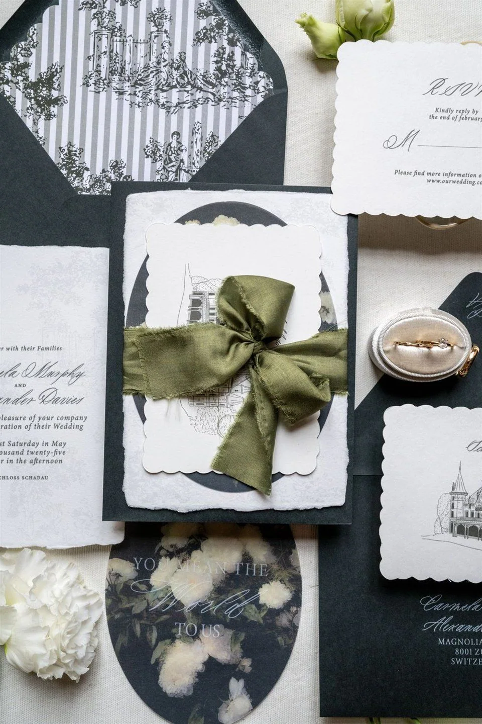 Invitations and menus with wedding rings and an olive green ribbon.