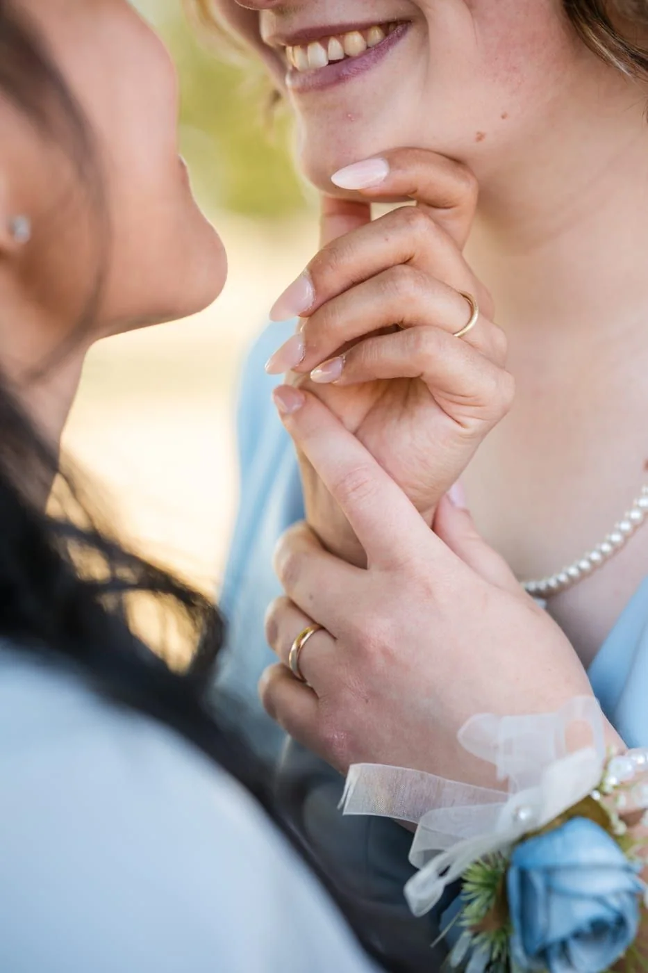Close-up of two hands with wedding rings.