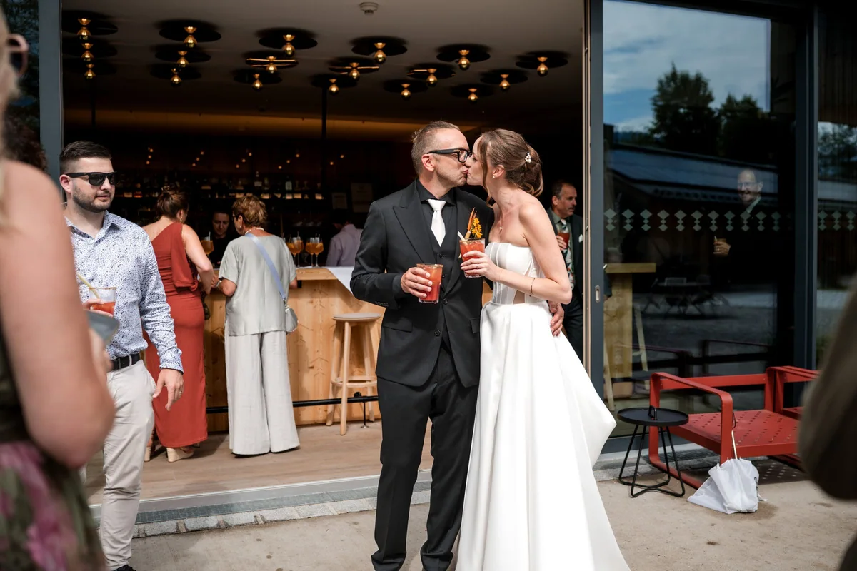 The wedding couple with drinks among their guests.