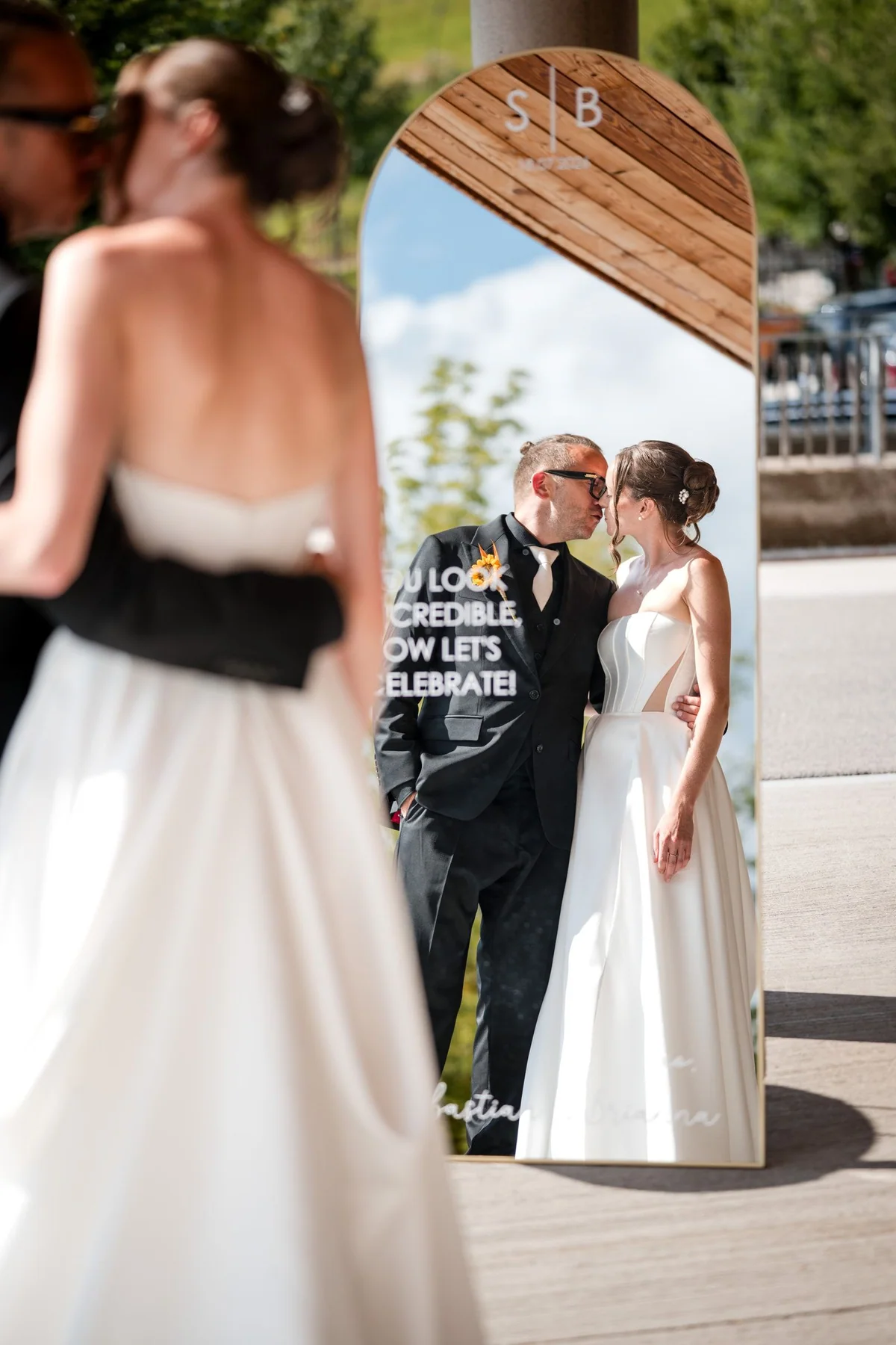 The wedding couple are reflected in the glass facade.