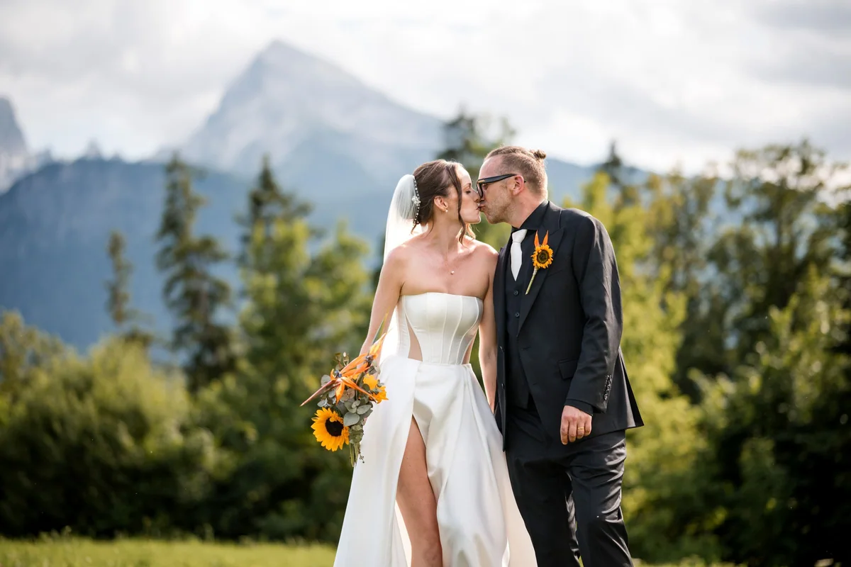 A kiss between a sunflower bouquet and mountain scenery.