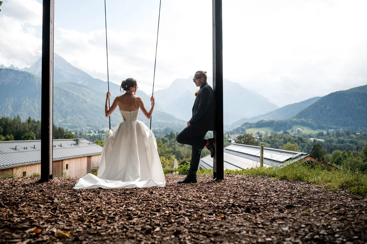 Brianna on a swing with her husband and a mountain view.