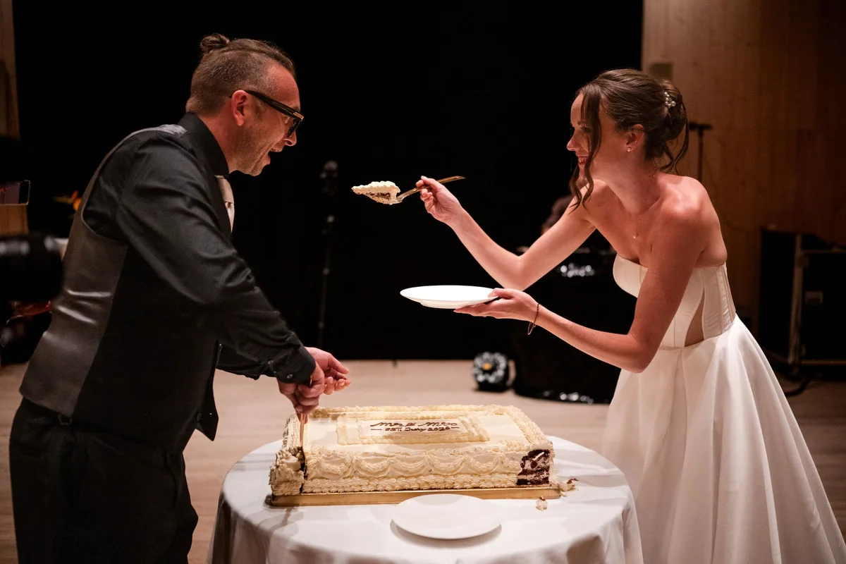 Brianna offers her husband a piece of wedding cake.