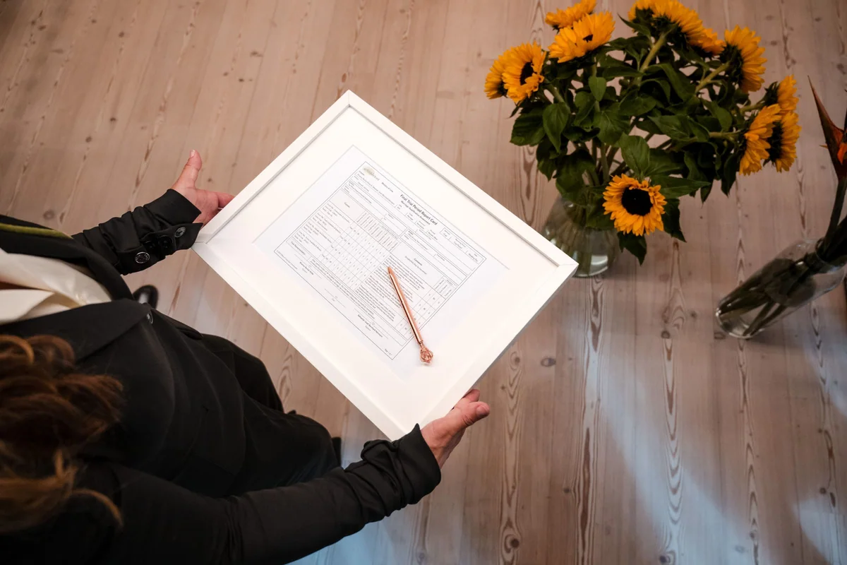 Ceremony documents beside a sunflower.