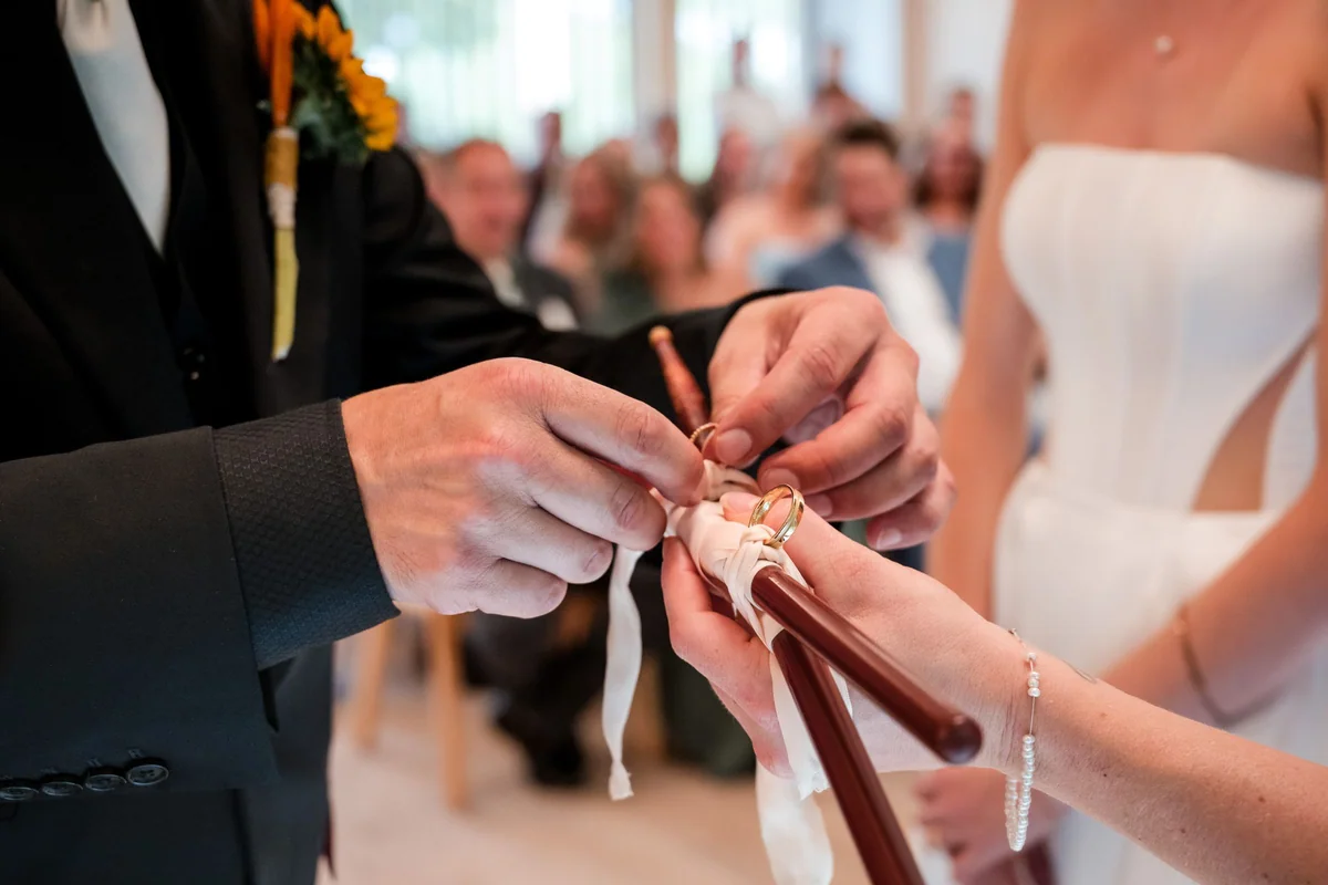 Close view of hands exchanging rings.