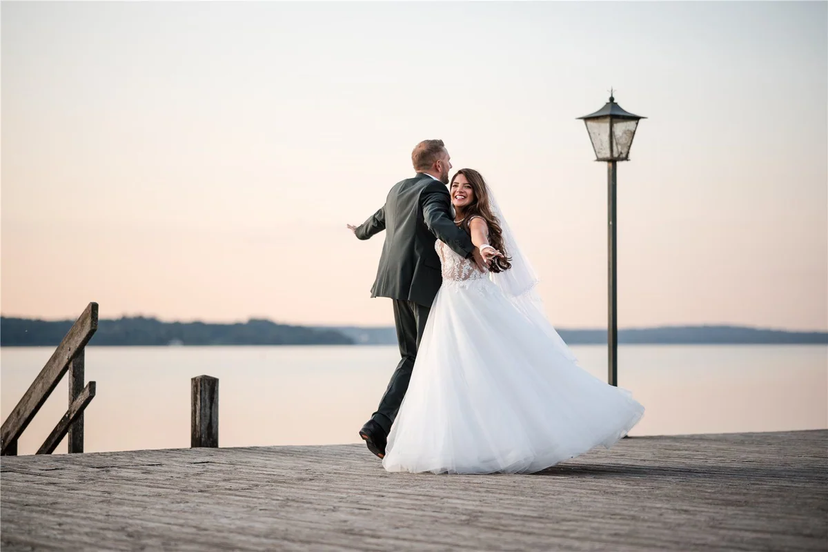 A couple spin on the jetty by the lake.
