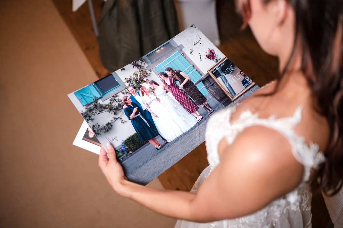 Eine Braut betrachtet den Ausdruck mit dem Familienfoto.